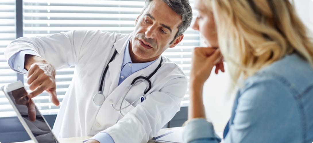 A doctor in a white lab coat talks with his EPI patient